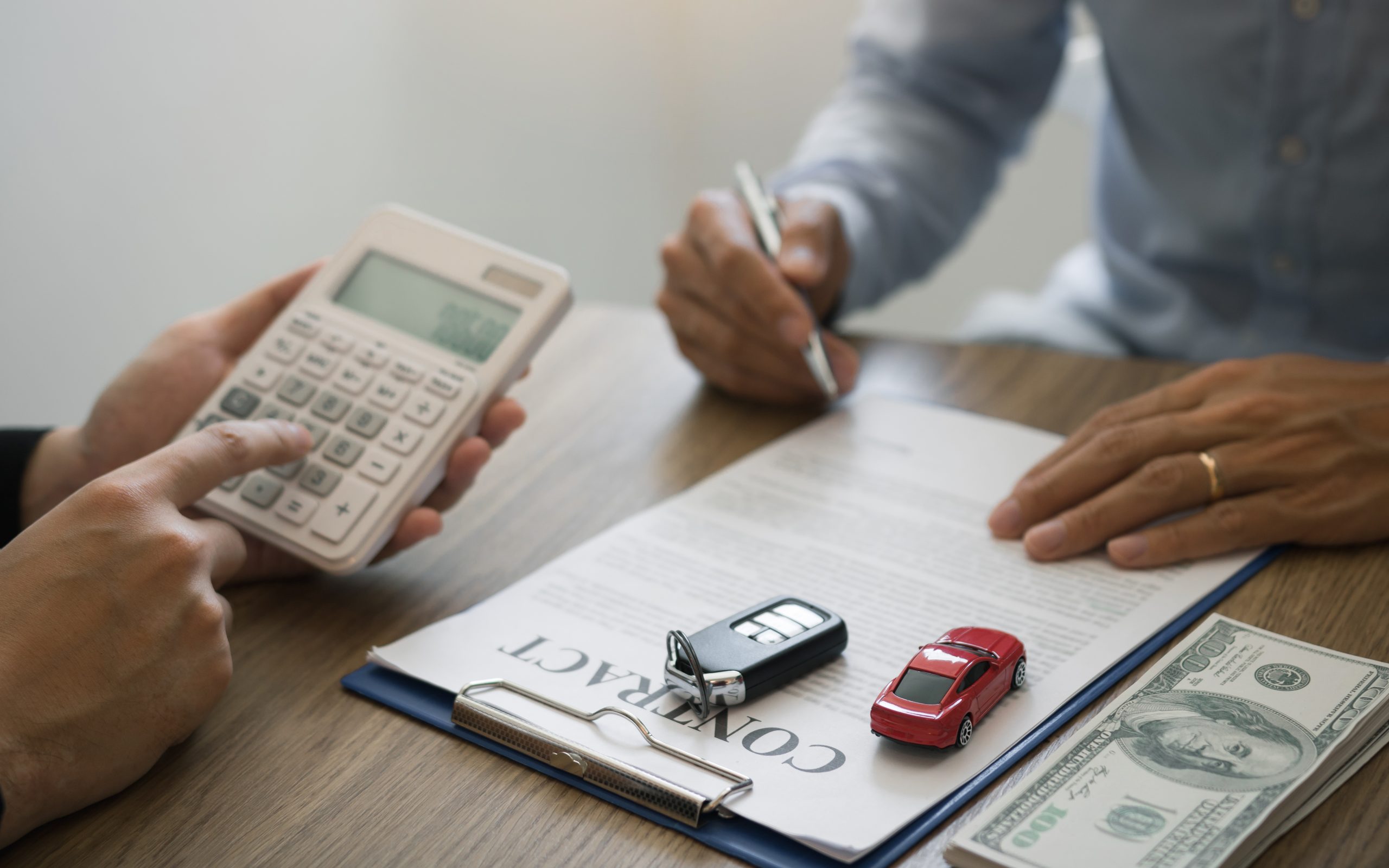 Finance manager of the car showroom is calculating the cost of reserving a new car for the customer while signing a car purchase contract.