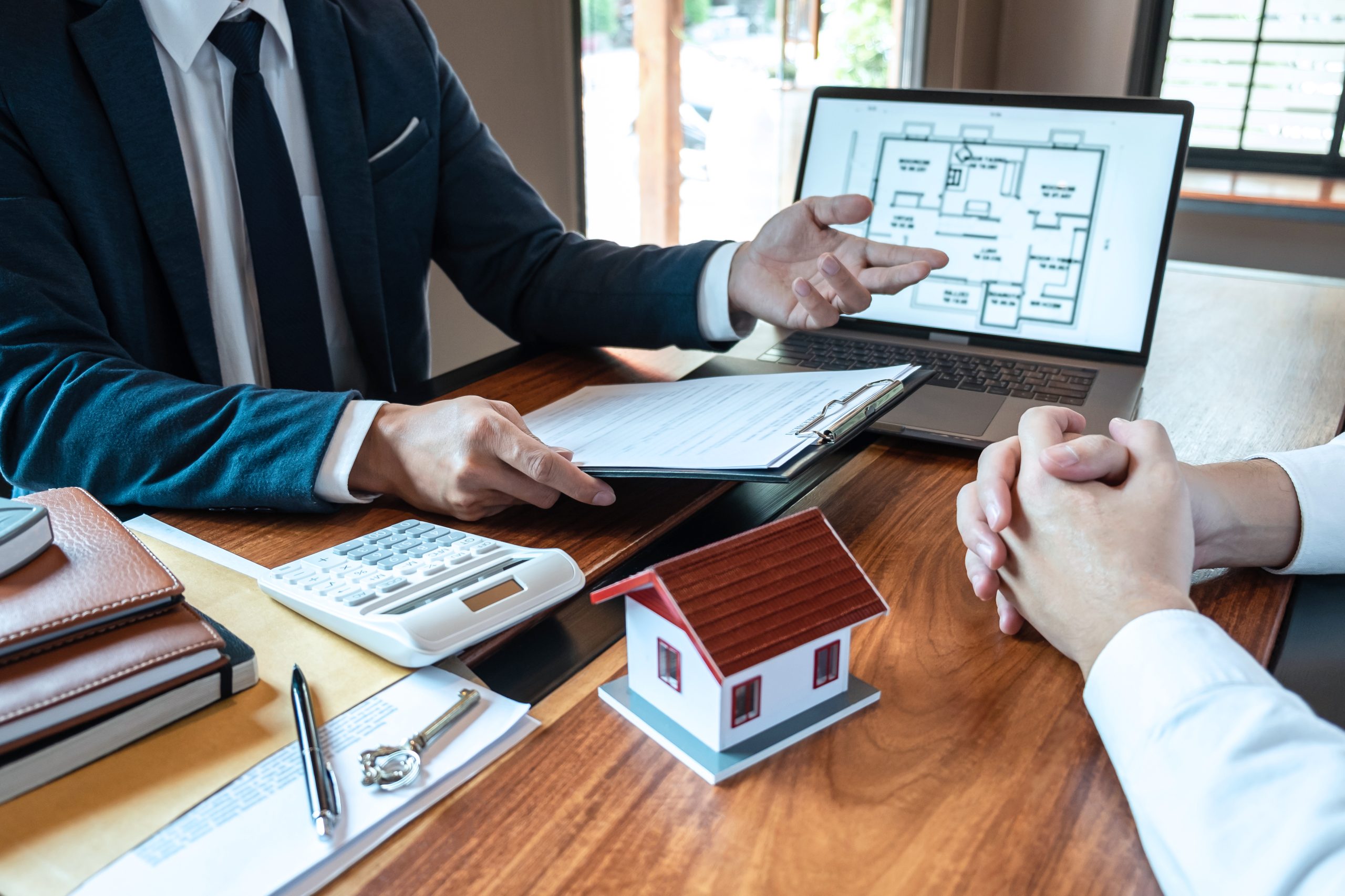 Real estate agent are presenting home loan and sending keys to customer after signing contract to buy house with approved property application form, Insurance Home concept.